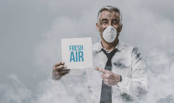 istock Man with pollution mask holding a sign 921119252