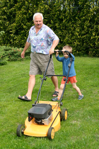 istock Grandfather and grandson mowing grass 92113438