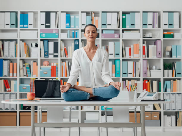 istock Woman practicing meditation on a desk 921142252