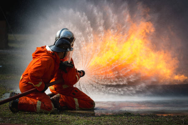 istock Firefighters training, Team practice to fighting with fire in emergency situation.Spray twist water to the flame 921145658