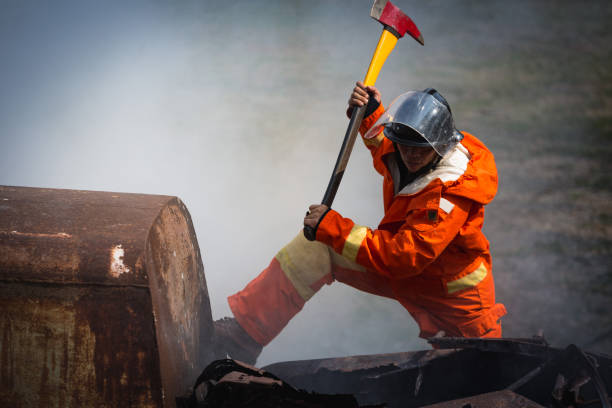 istock Firefighters training, Team practice to fighting with fire in emergency situation. A fireman use an axe open burnt place 921145722