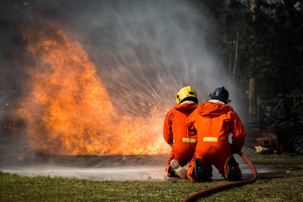 istock Firefighters training, Team practice to fighting with fire in emergency situation.Spray water to the flame 921145724