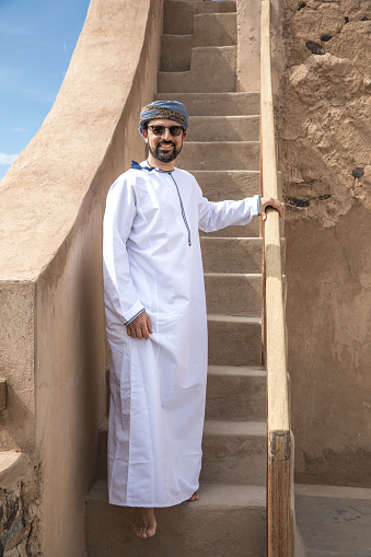 hombre árabe tradicional traje Omaní caminando por las escaleras photo