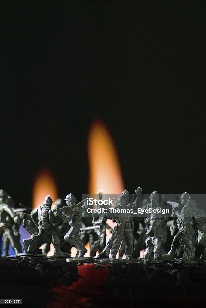 Игрушка lead-солдат, поставленные в борьбе с flame сзади. - Стоковые фото Агрессия роялти-фри