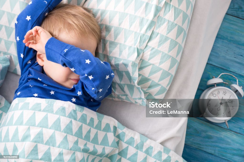 One year old baby crying Three years old child crying in bed. Boy hiding and closing eyes with hands Child Stock Photo