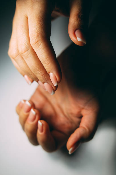 istock French nail extensions. Women at beauty parlour doing classic manicure. 921157748