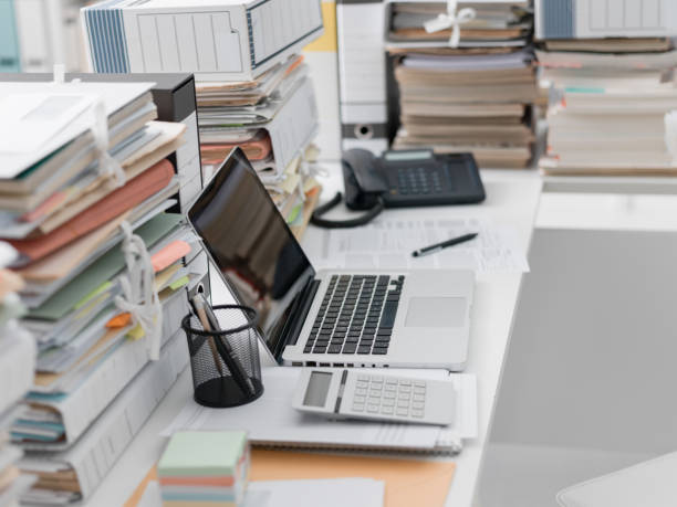 istock Office desk with piles of paperwork 921157828
