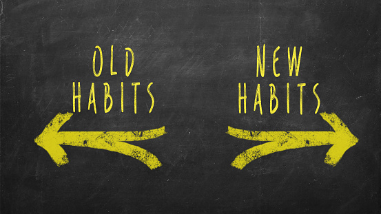 Old Habits - New Habits drawn with yellow arrows on chalkboard