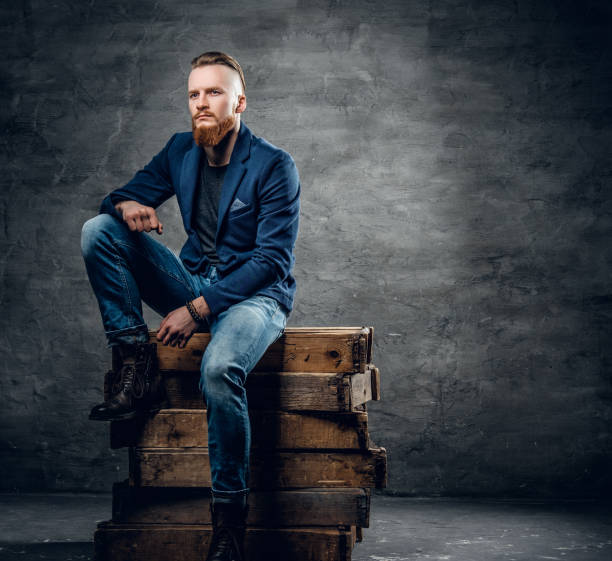 istock Redhead bearded hipster male posing on a wooden box. 921176344