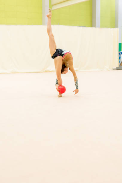 istock Young Rhythmic Gymnast Doing a Pirouette with a Ball in her Hands 921176482