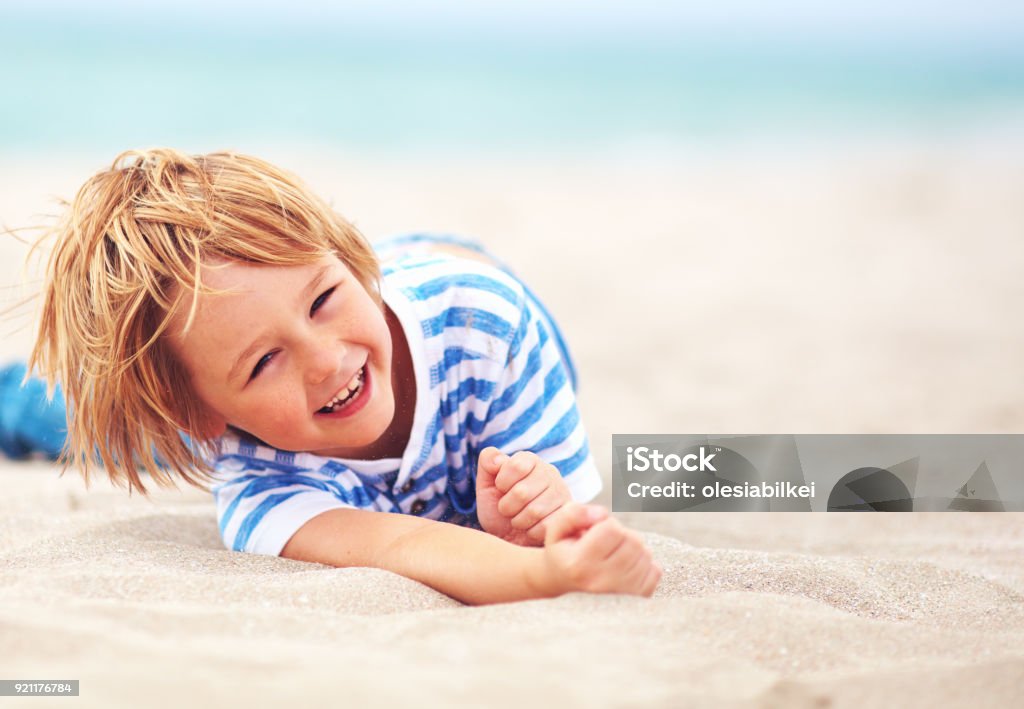 Cute heureux garçon riant, kid s’amuser sur la plage de sable fin, vacances d’été - Photo de Enfant libre de droits