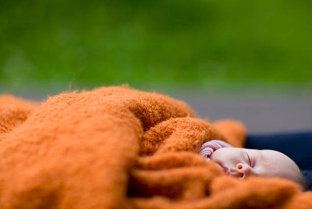 Boy in orange t-shirt sleeping on the couch at home.