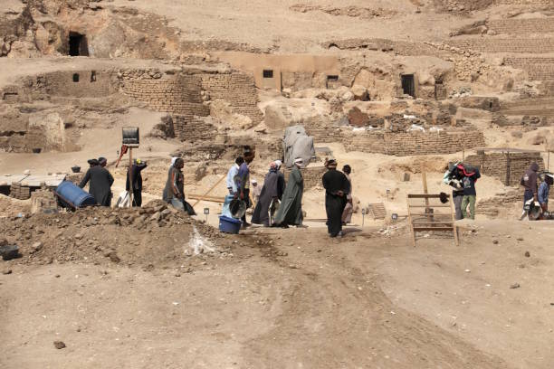 Archaeological excavation in the Valley of the Kings, Egypt Valley of the Kings, Luxor, Egypt, February, 2018. Workers are working on archaeological site in the Valley of the Kings in Egypt. They carry the sand and stones and they are surrounded by dust and sand. Arheopčpgists in this site are looking for the remains of the ancient Egyptian civilization. grave digger stock pictures, royalty-free photos & images