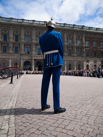 Royal Guards waving flags outside the Stockholm Palace at a guard rotation, on a sunny day in Stockholm, Sweden