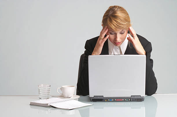 働き、ストレスのたまったビジネスウーマンには頭痛ノートパソコン - appointee ストックフォトと画像
