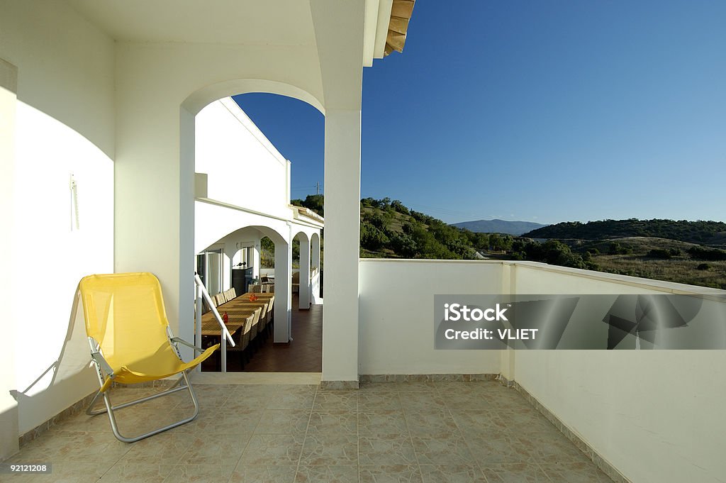 Bianco di villeggiatura balcone con sedia in estate giallo - Foto stock royalty-free di Alberato