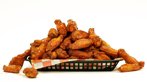 Some spicy glazed chicken wings in a black basket A mountain of Chicken Wings. breaded photos stock pictures, royalty-free photos & images
