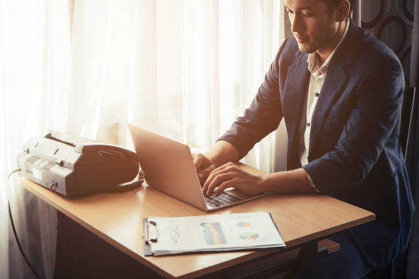 Business man is working on computer on the desk by the windows stock photo