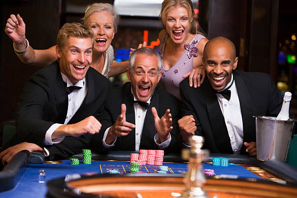 cinco personas jugando a la ruleta en un casino - roulette table fotografías e imágenes de stock