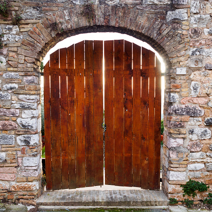 Old wooden door in Spello (Italy). Square format.