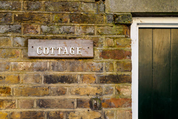 istock Cottage wooden sign on a brick wall. 921245786
