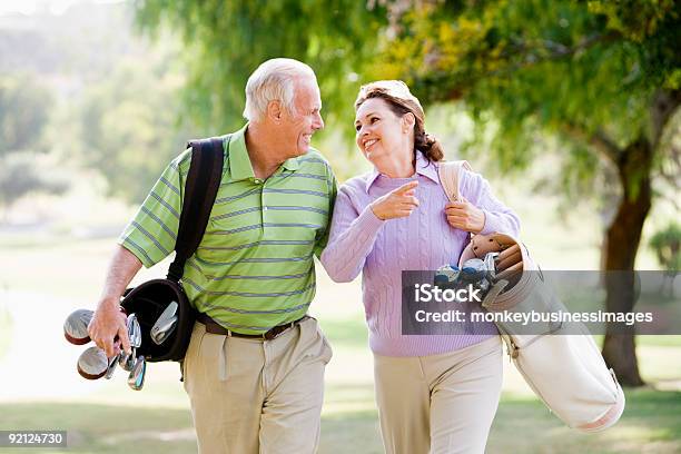 Couple Enjoying A Game Of Golf Stock Photo - Download Image Now - Golf, 50-59 Years, Golf Course
