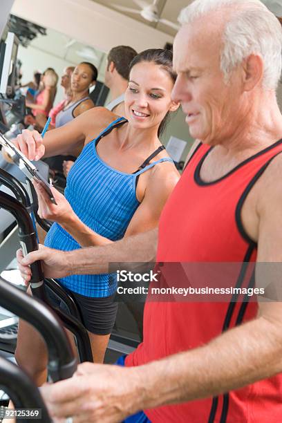 Personal Trainer Instructing Man Stock Photo - Download Image Now - 20-29 Years, 40-49 Years, 60-69 Years