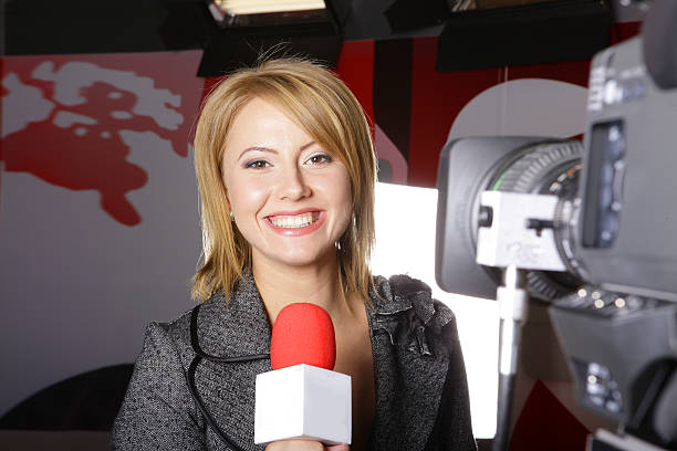 Real television news reporter and video camera stock photo
