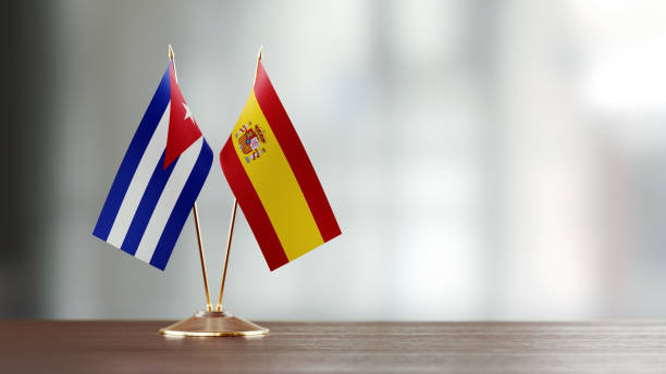 istock Cuban And Spanish Flag Pair On A Desk Over Defocused Background 921257400