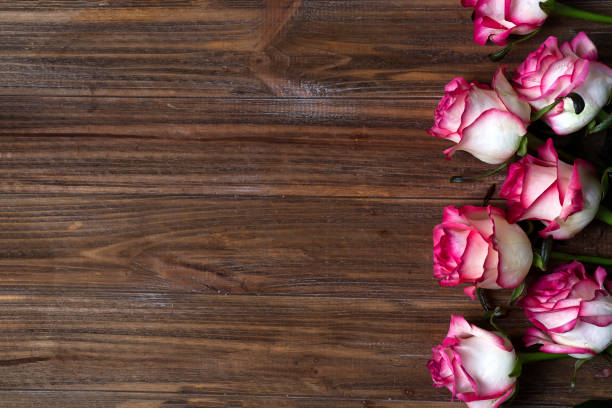 istock Roses frame on wooden brown background 921264292