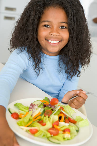 istock Young girl in kitchen eating salad smiling 92126450