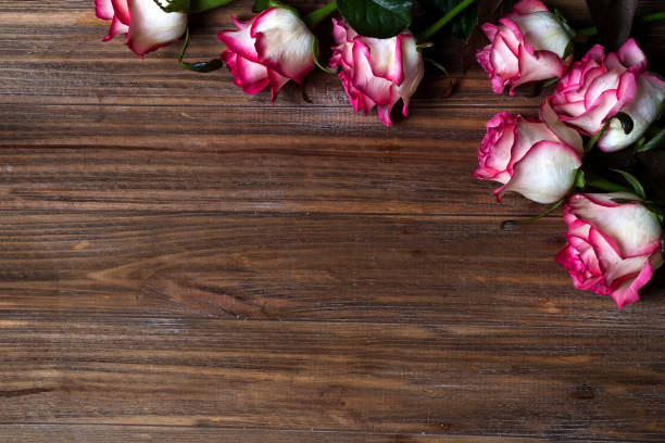 istock Roses frame on wooden brown background 921266384