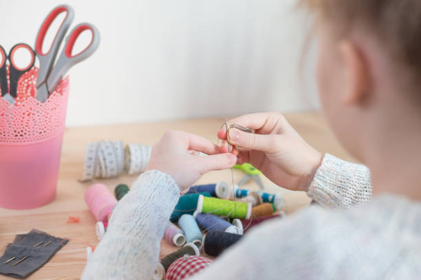 istock girl sews doll clothes 921266472