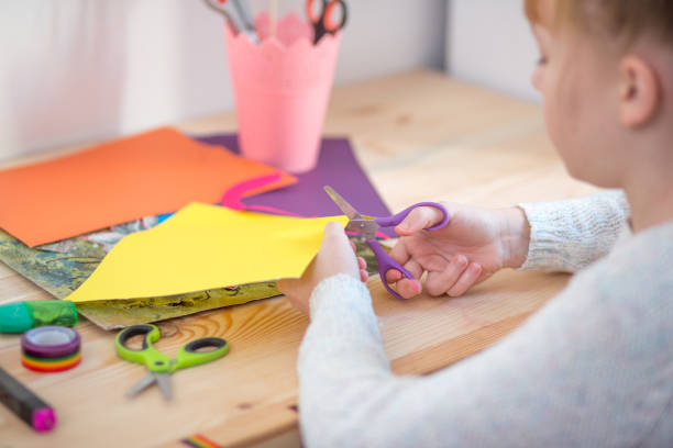 istock Girl play with scissors and color paper 921267148