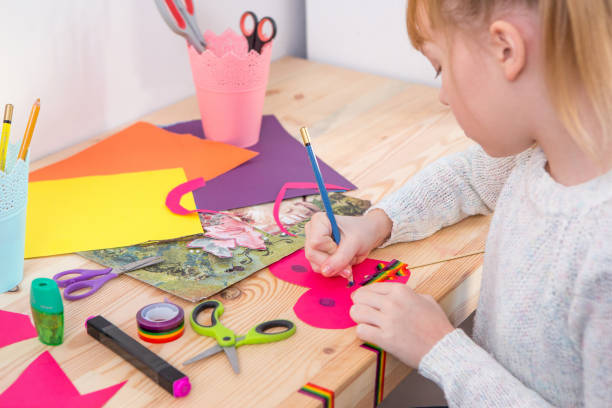 istock Girl play with scissors and color paper 921269824