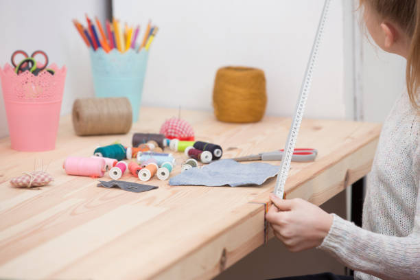 istock girl sews doll clothes 921270320