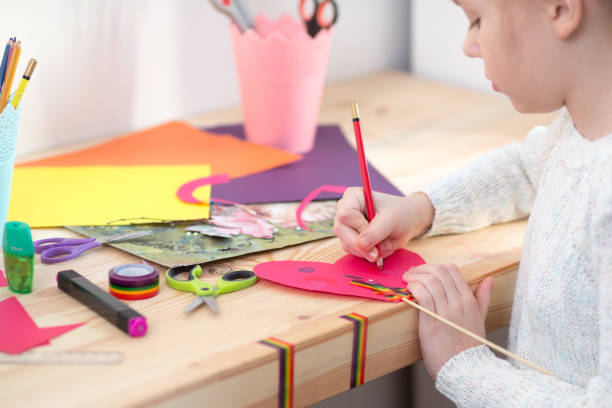 istock Girl play with scissors and color paper 921271010
