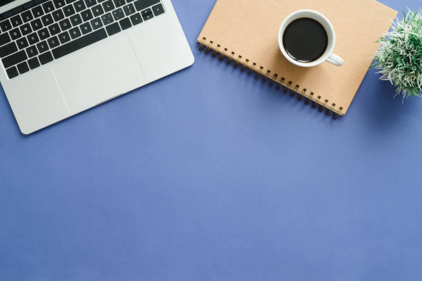 istock Minimal work space - Creative flat lay photo of workspace desk. Top view office desk with laptop, notebooks and coffee cup on blue color background. Top view with copy space, flat lay photography. 921274024
