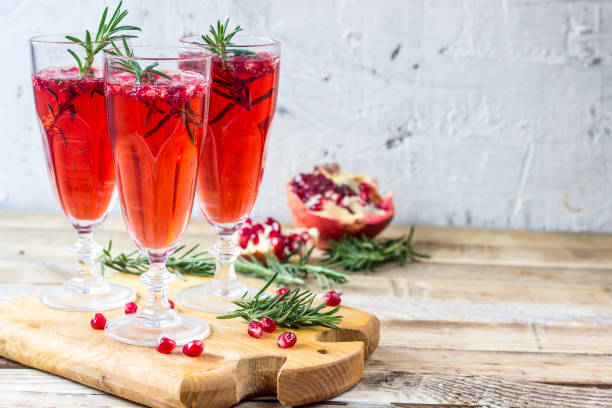 Pomegranate champagne mimosa cocktail Pomegranate champagne mimosa cocktail with rosemary in glasses on wooden background punch drink stock pictures, royalty-free photos & images