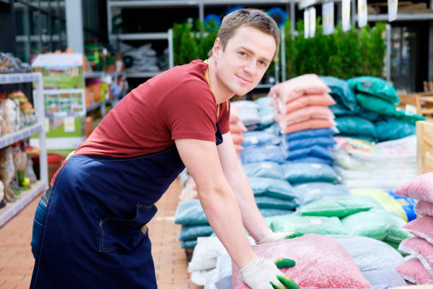 istock young man worker in plant market greenhouse at work 921276516