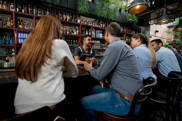 istock People having drinks and talking to the barman at the bar 921276690
