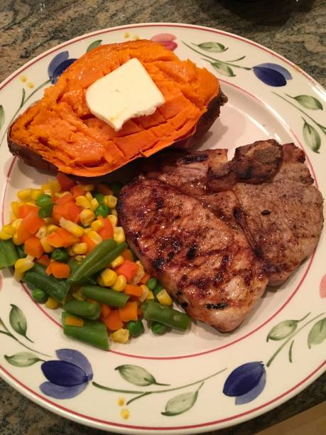 istock Grilled Pork Chop, Sweet Potato and Vegetables 921277342