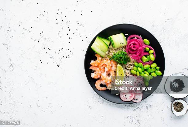 Foto de Receita De Marisco Fresco Camarão Poke Tigela Com Camarão Fresco Arroz Integral Pepino Cebola Doce Em Conserva Rabanete Feijão De Soja Edamame Porções Com Gergelim Preto E Branco Bacia De Puxão Do Conceito De Alimento Vista Superior e mais fotos de stock de Poké - Comida