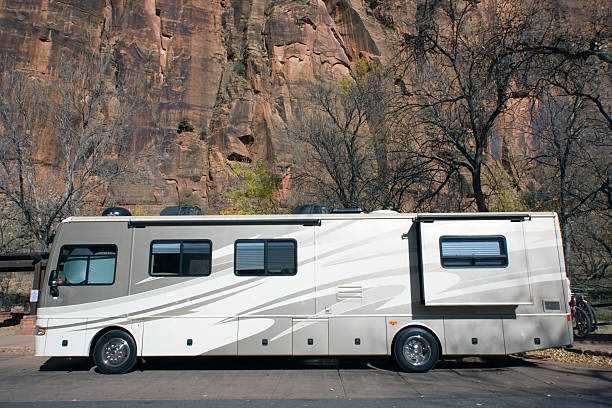 A luxury RV parked in the woods Brand New Luxury RV against the rocks of Zion National Park. natural bridges national park photos stock pictures, royalty-free photos & images