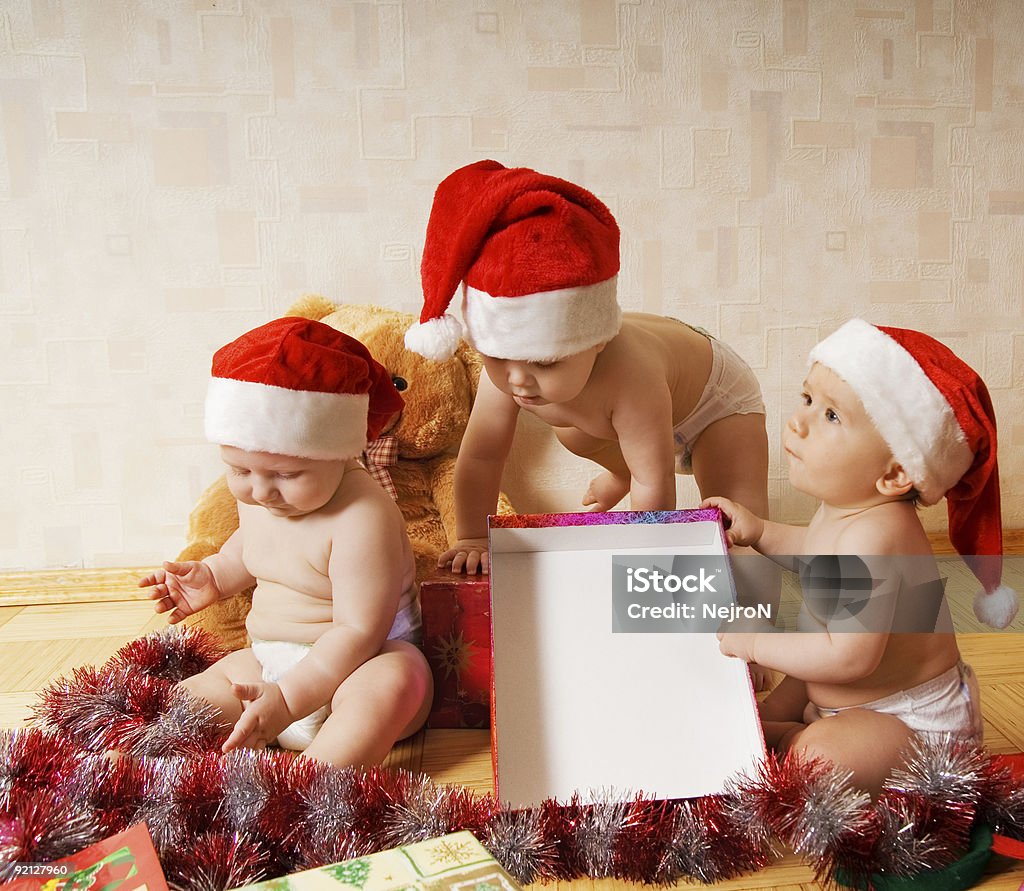 Grupo de adoráveis crianças pequenas em chapéus de Natal apresenta embalagem - Foto de stock de Alegria royalty-free