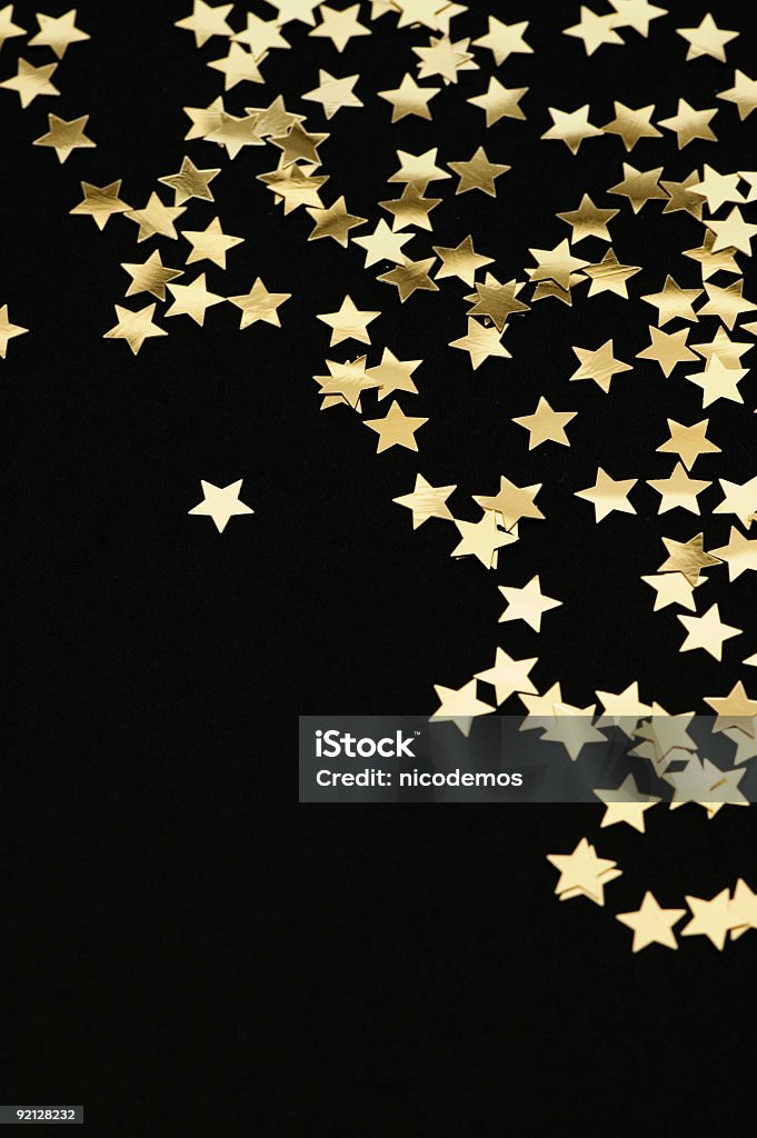 Golden stars falling from the top on black background Golden Stars Gold Colored Stock Photo