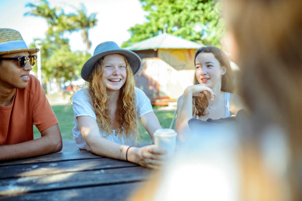 istock Young friends sitting in the park and talking 921284202