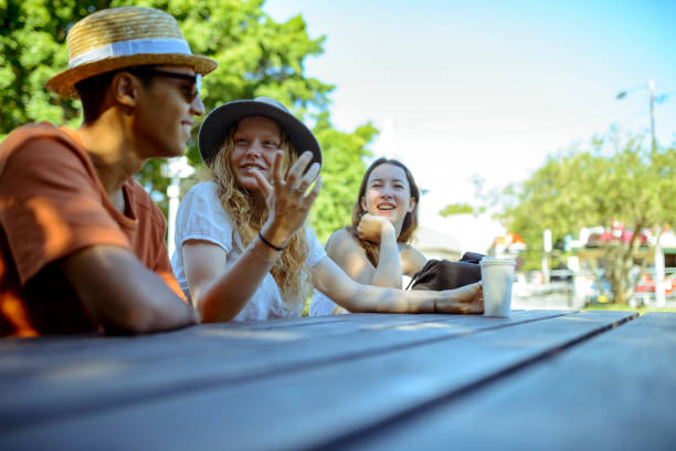 公園で座っていると話している若いお友達 - travel teenager talking student ストックフォトと画像