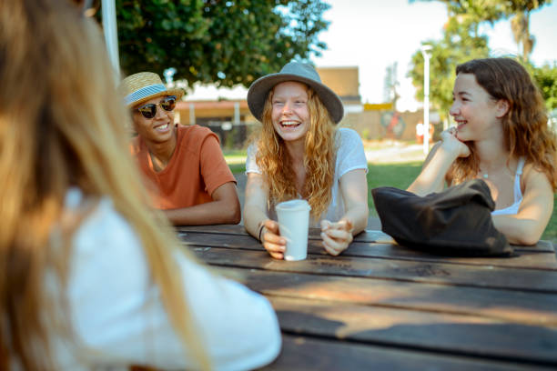 jovens amigos sentado no parque e falar - travel teenager talking student - fotografias e filmes do acervo