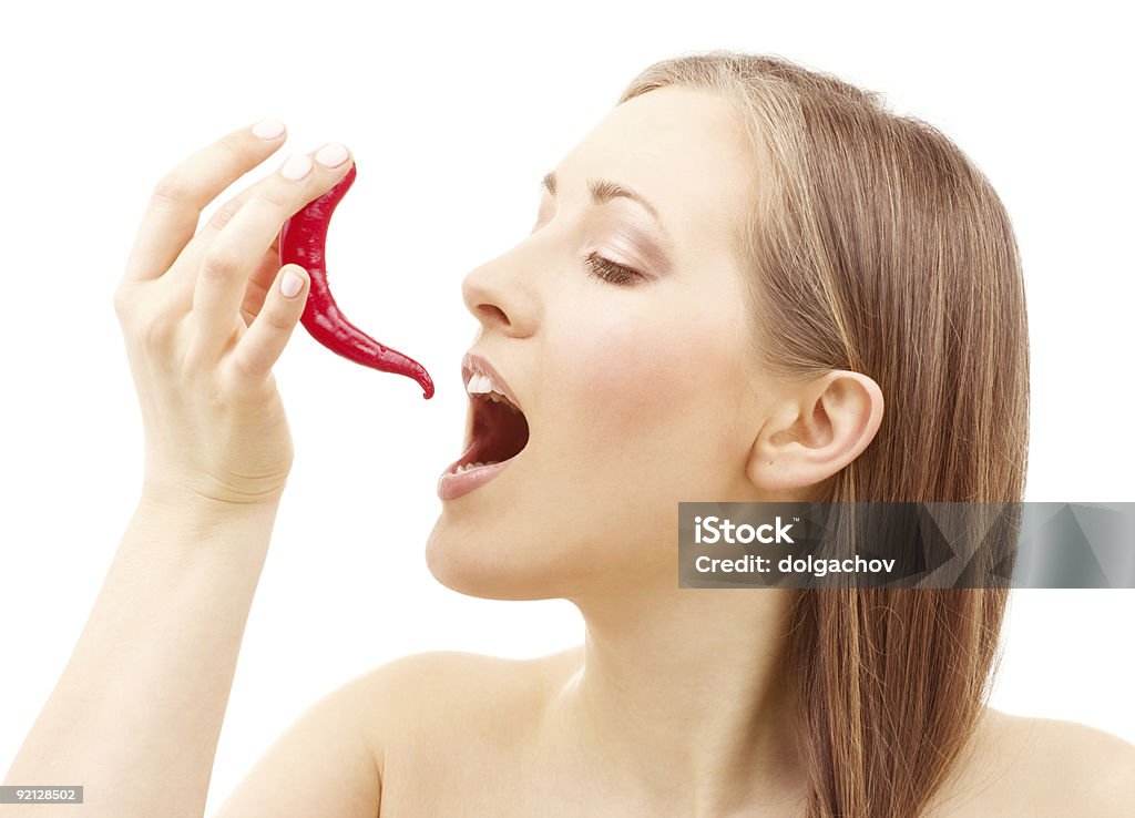 Bare shouldered woman opening mouth to eat a red pepper picture of lovely woman with hot chili pepper Adult Stock Photo